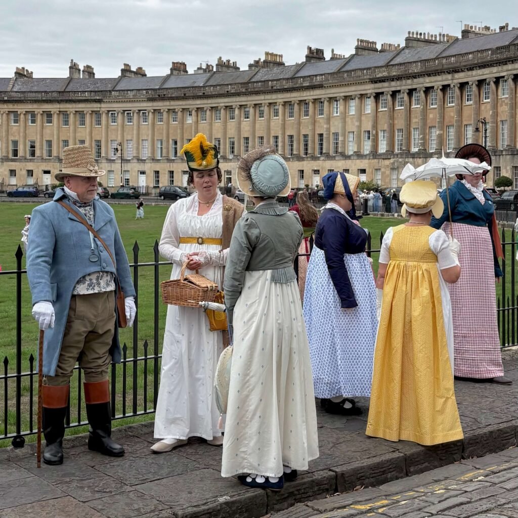 Regency-dressed visitors chatting near the Royal Crescent during the Jane Austen Festival